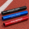 Personalized black, blue, and red aluminum relay batons with silver engraving on a running track